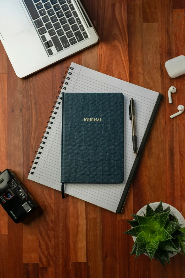 black spring notebook brown wooden table illustrating atomic habits vs tiny habits