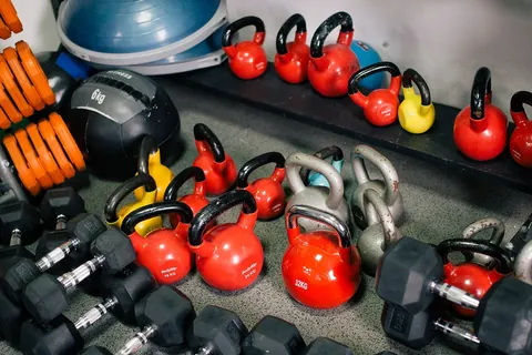 kettlebells and dumbbells on gym shelves representing strength training