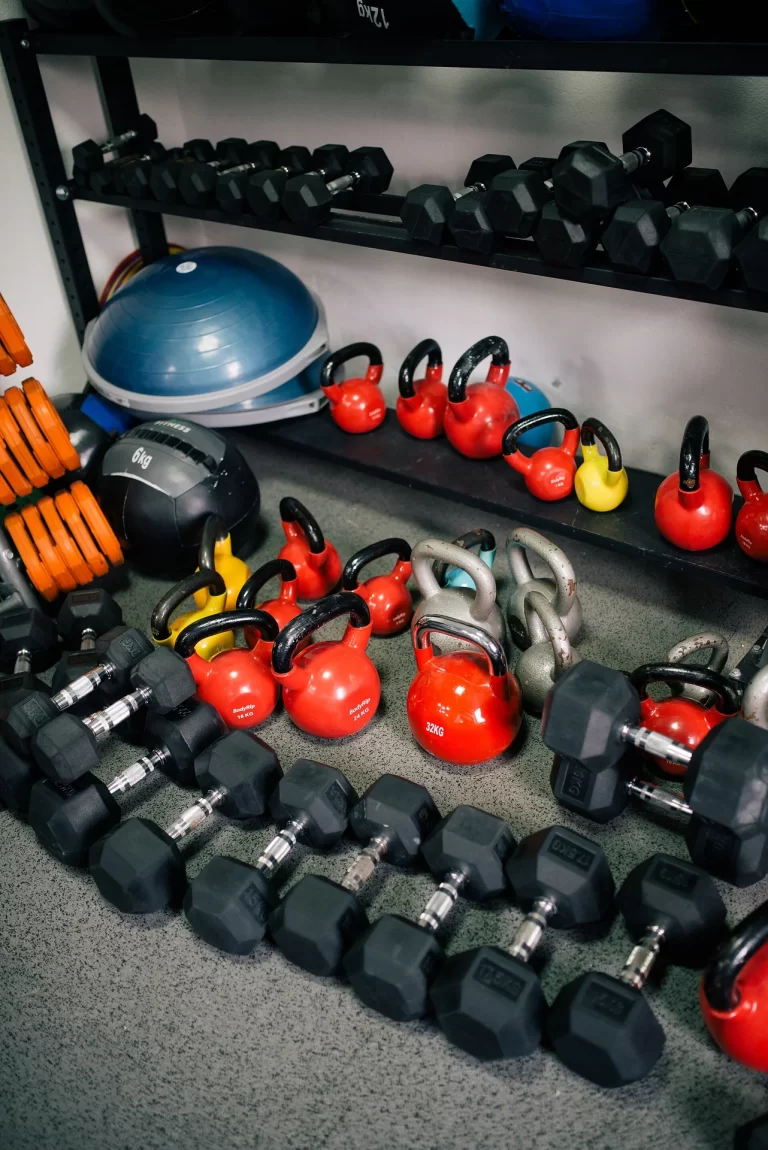 kettlebells and dumbbells on gym shelves representing strength training