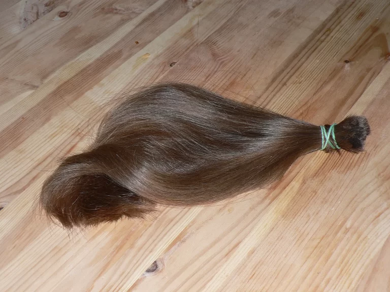 a cut-off ponytail lying on the floor representing hair loss