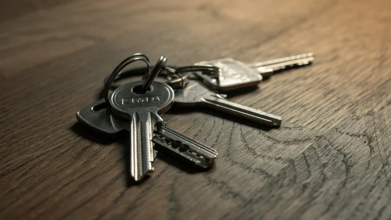 bunch keys sitting top wooden table illustrating buying vs renting a home
