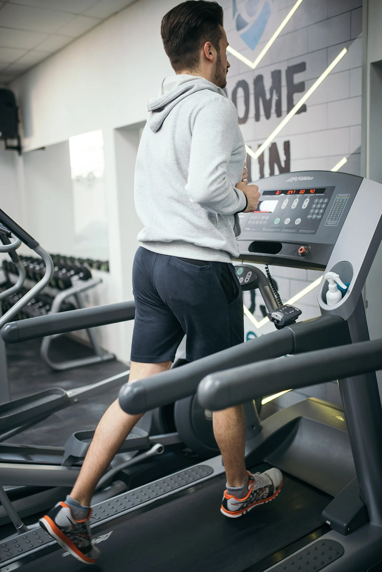 fit man running on treadmill at moderate steady pace for zone 2 aerobic training
