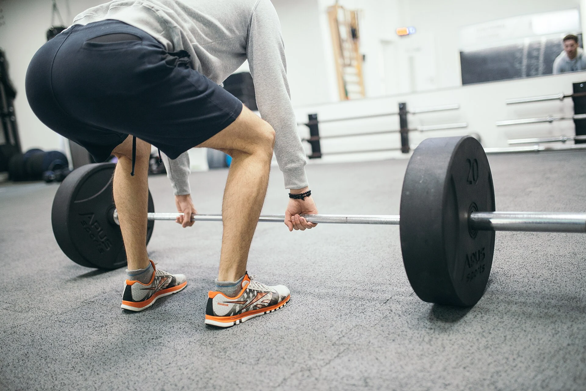 man doing barbell deadlift for full body strength training in gym