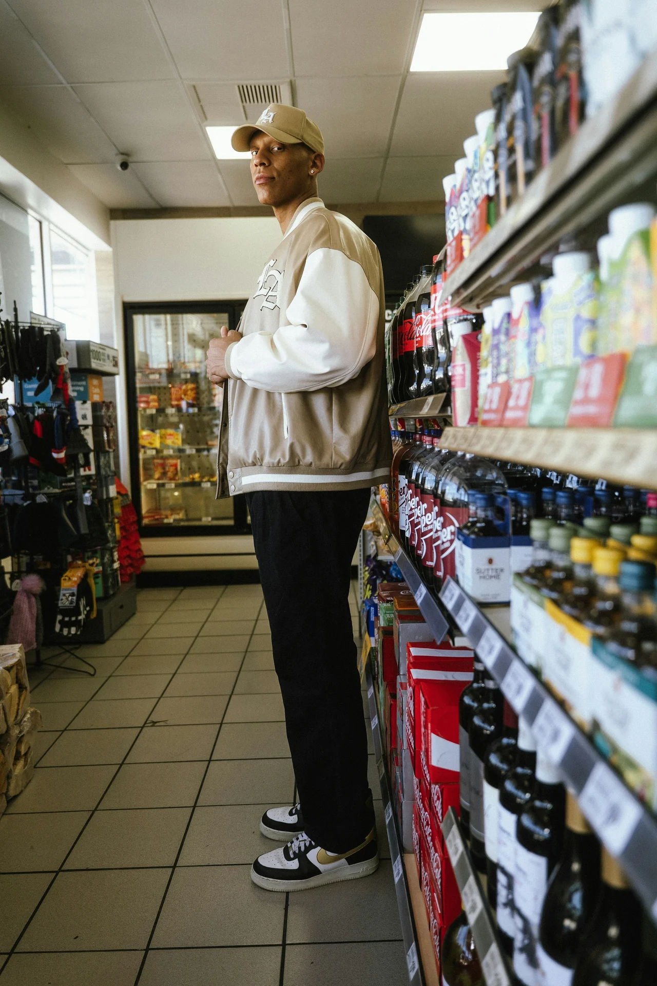 man turning a supplement bottle over to read the ingredient panel in a store aisle