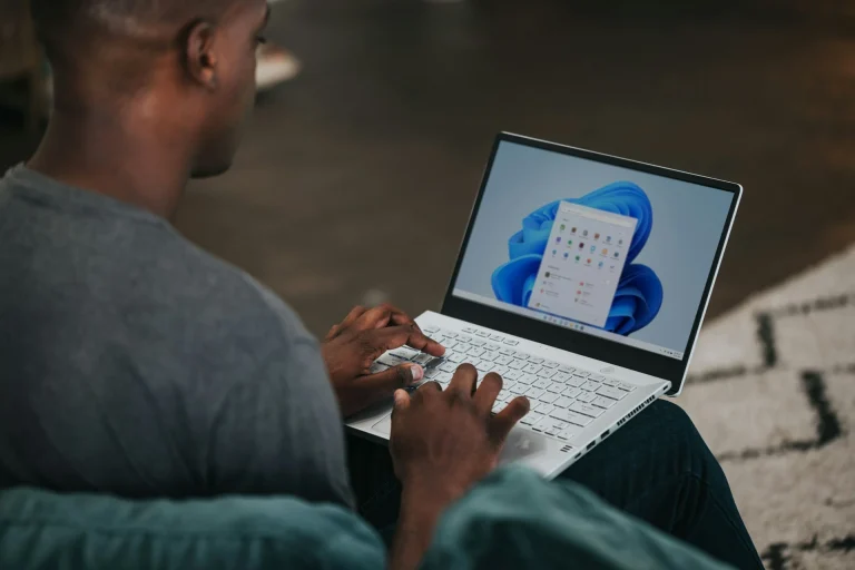 man gray long sleeve shirt using windows 11 computer illustrating how to pick a high-yield savings account