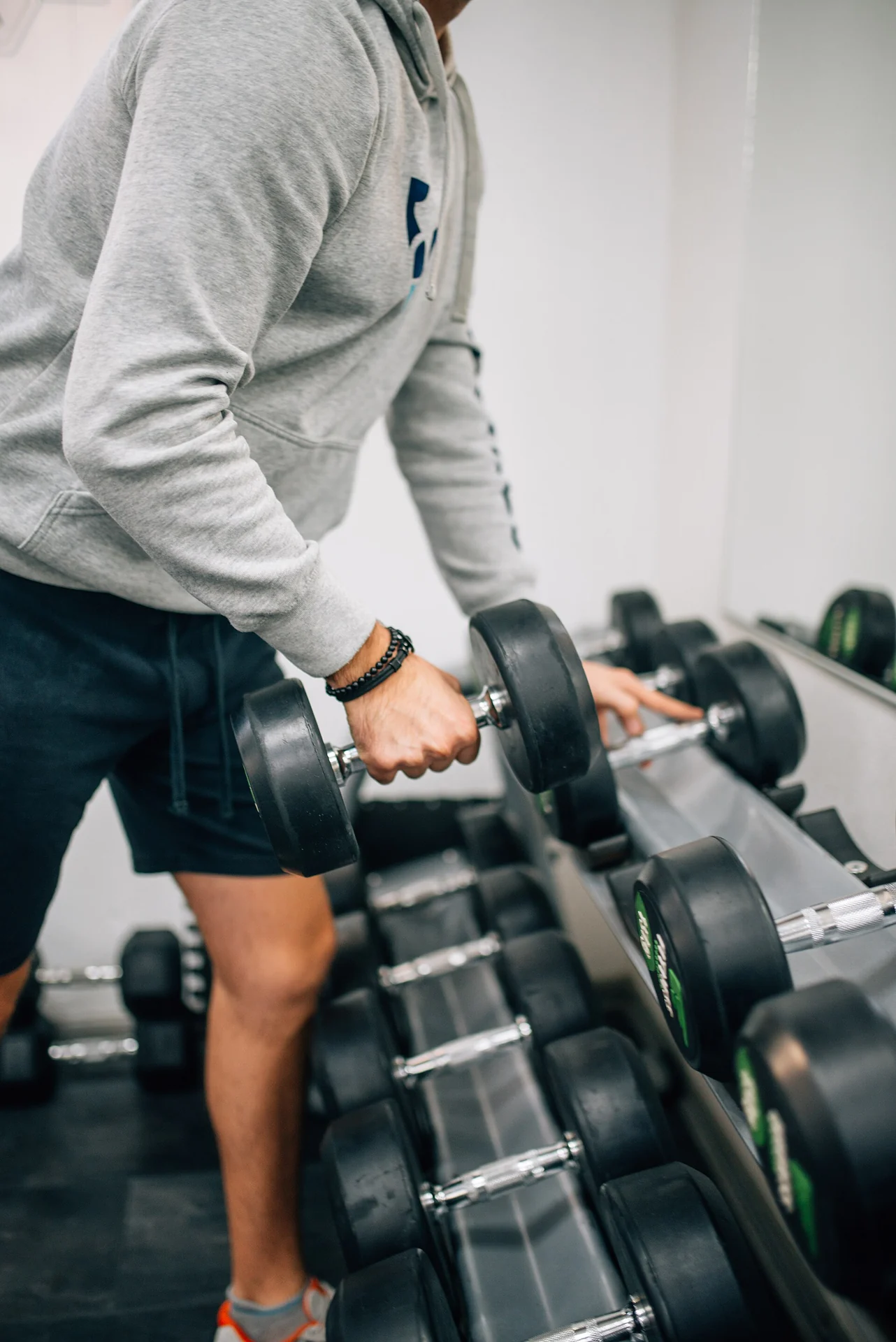 man lifting dumbbell for strength training to preserve muscle during fat loss