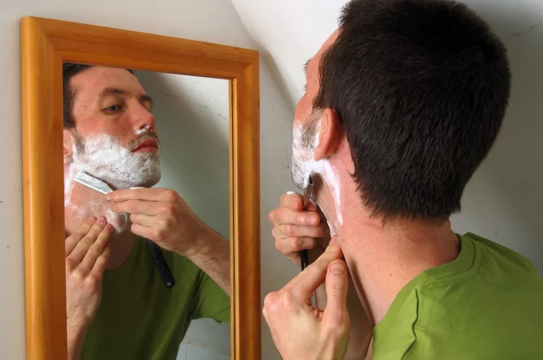 man shaving with a straight razor representing a grooming routine