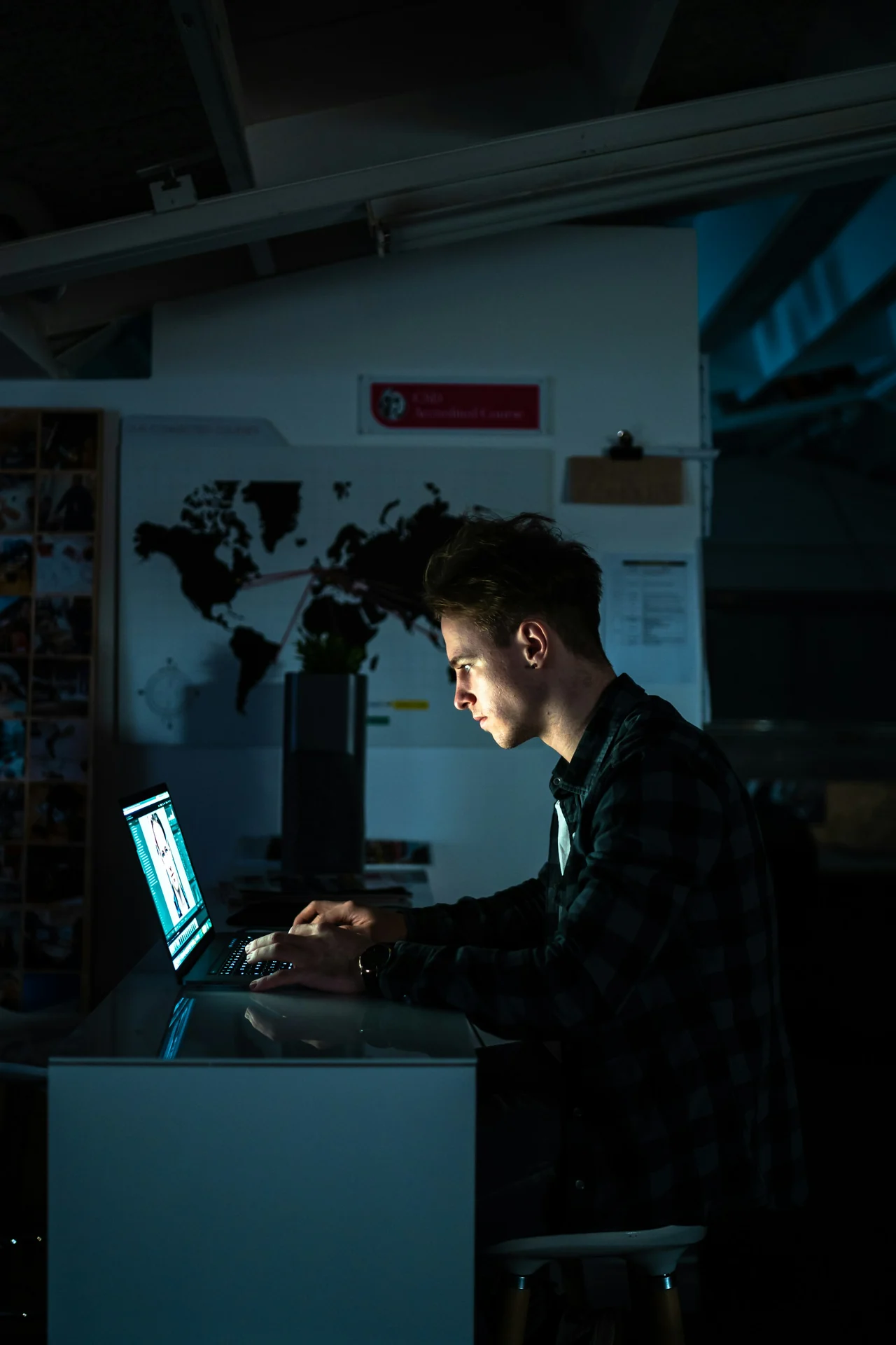 man sitting on the edge of a bed at night looking at his phone