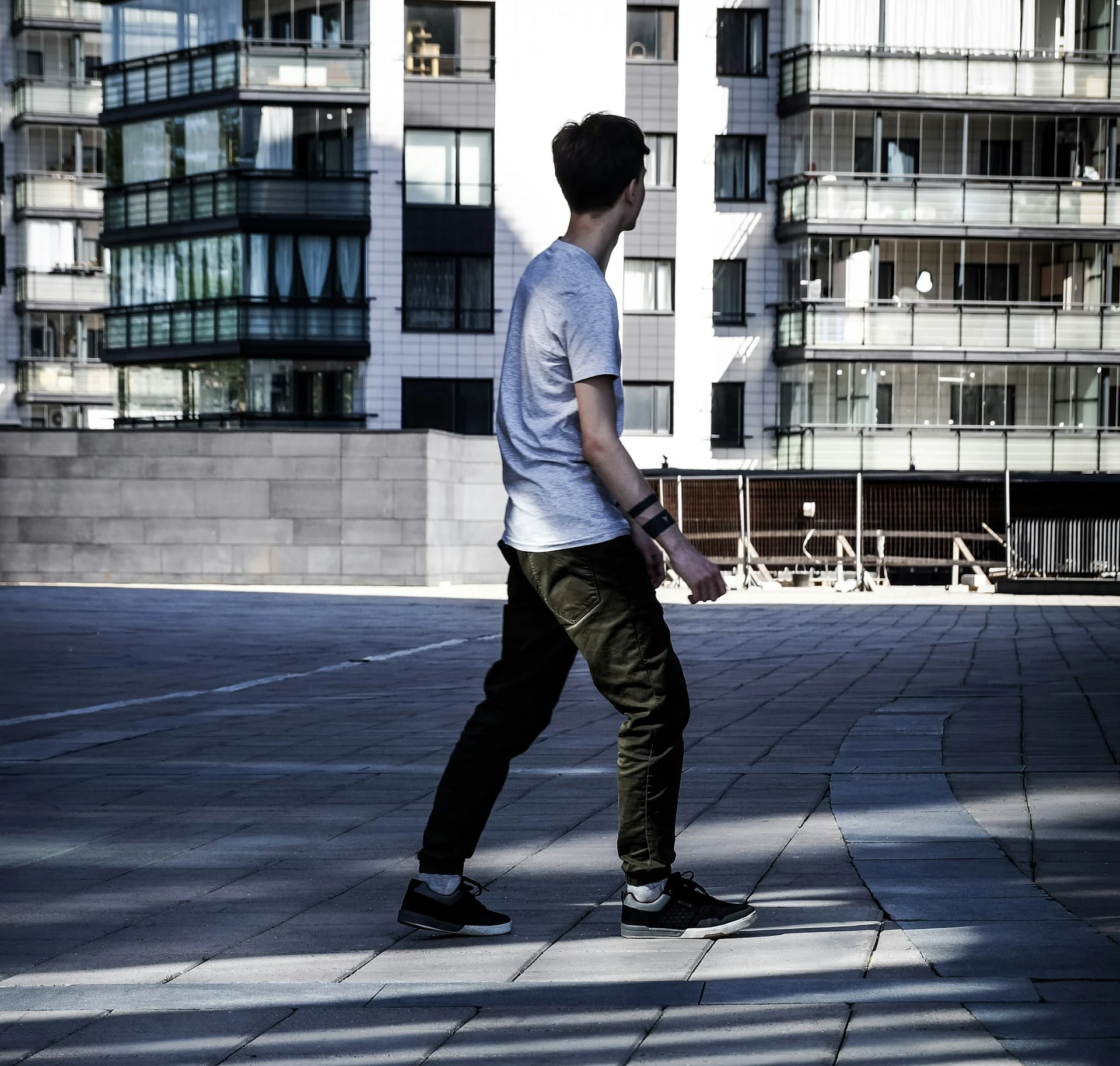 man walking outdoors in well fitted everyday clothes in early morning light