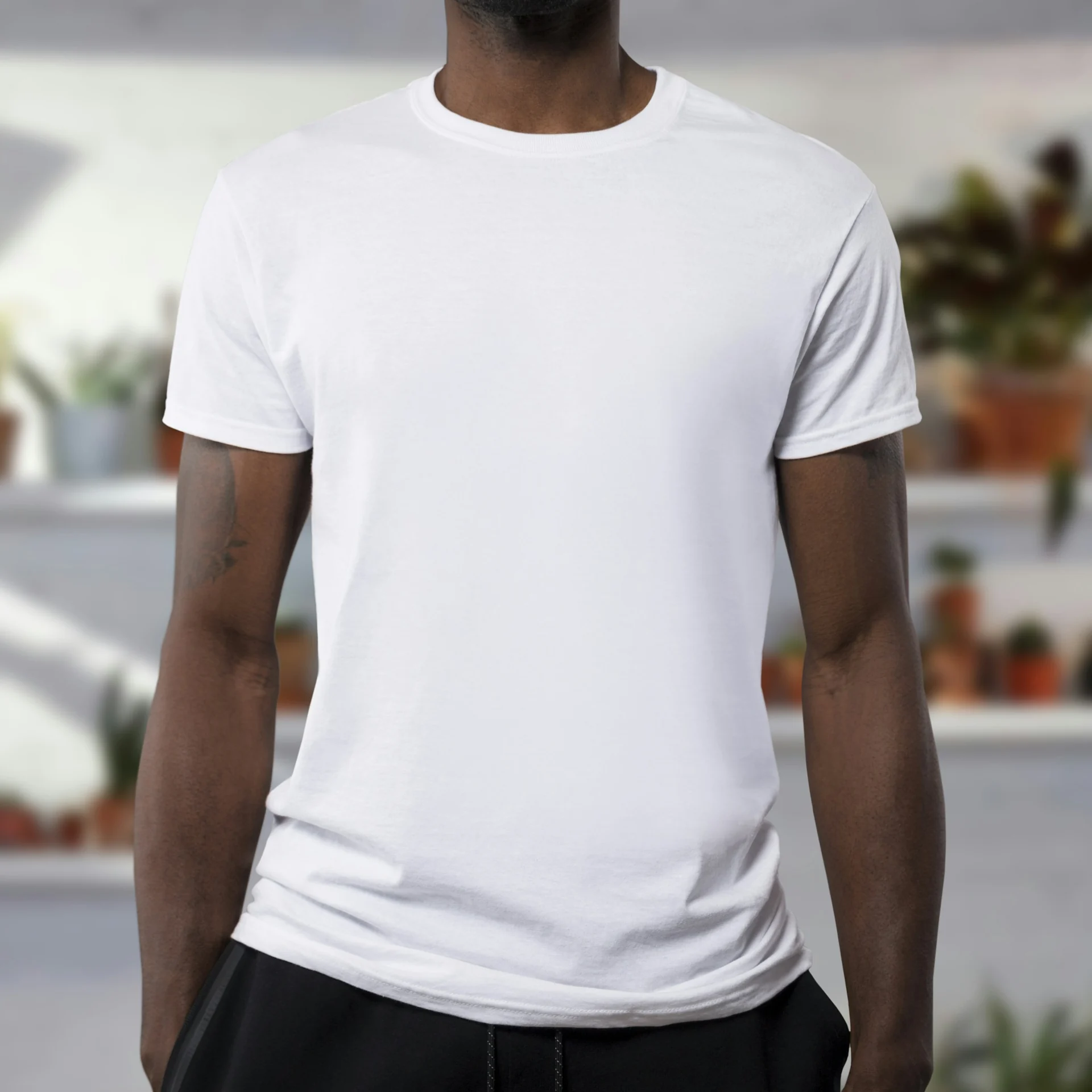 man standing in daylight wearing a plain white crew neck t-shirt