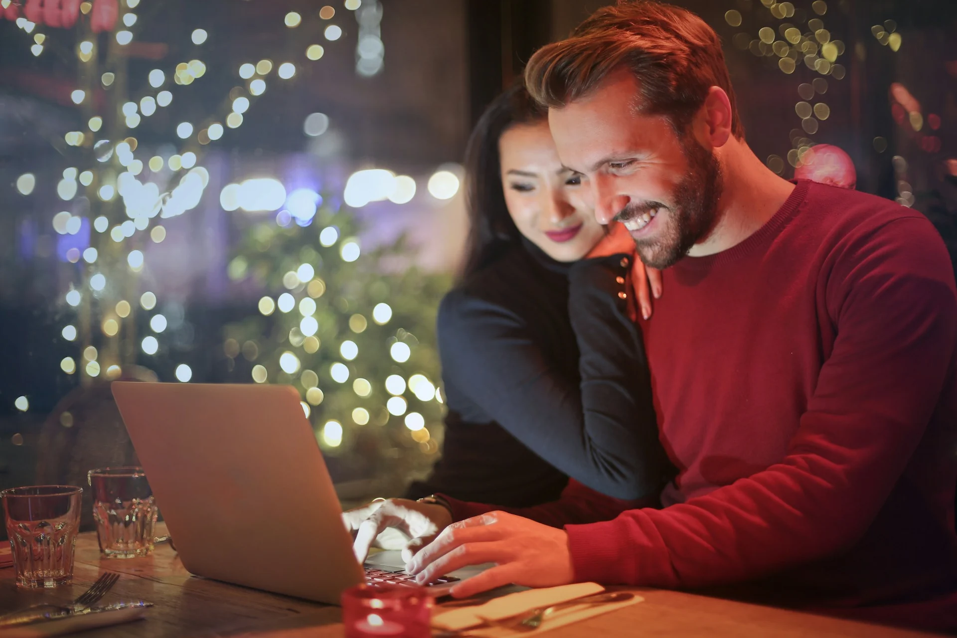 couple reviewing a housing cost breakdown on a laptop at a dining table