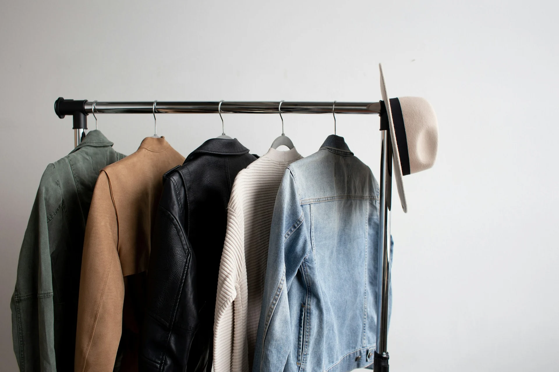 row of shirts, jackets and trousers hanging on a wardrobe rail