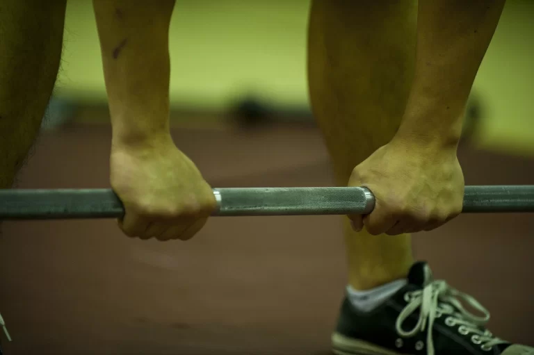 athlete preparing a sumo deadlift high pull representing compound lifting