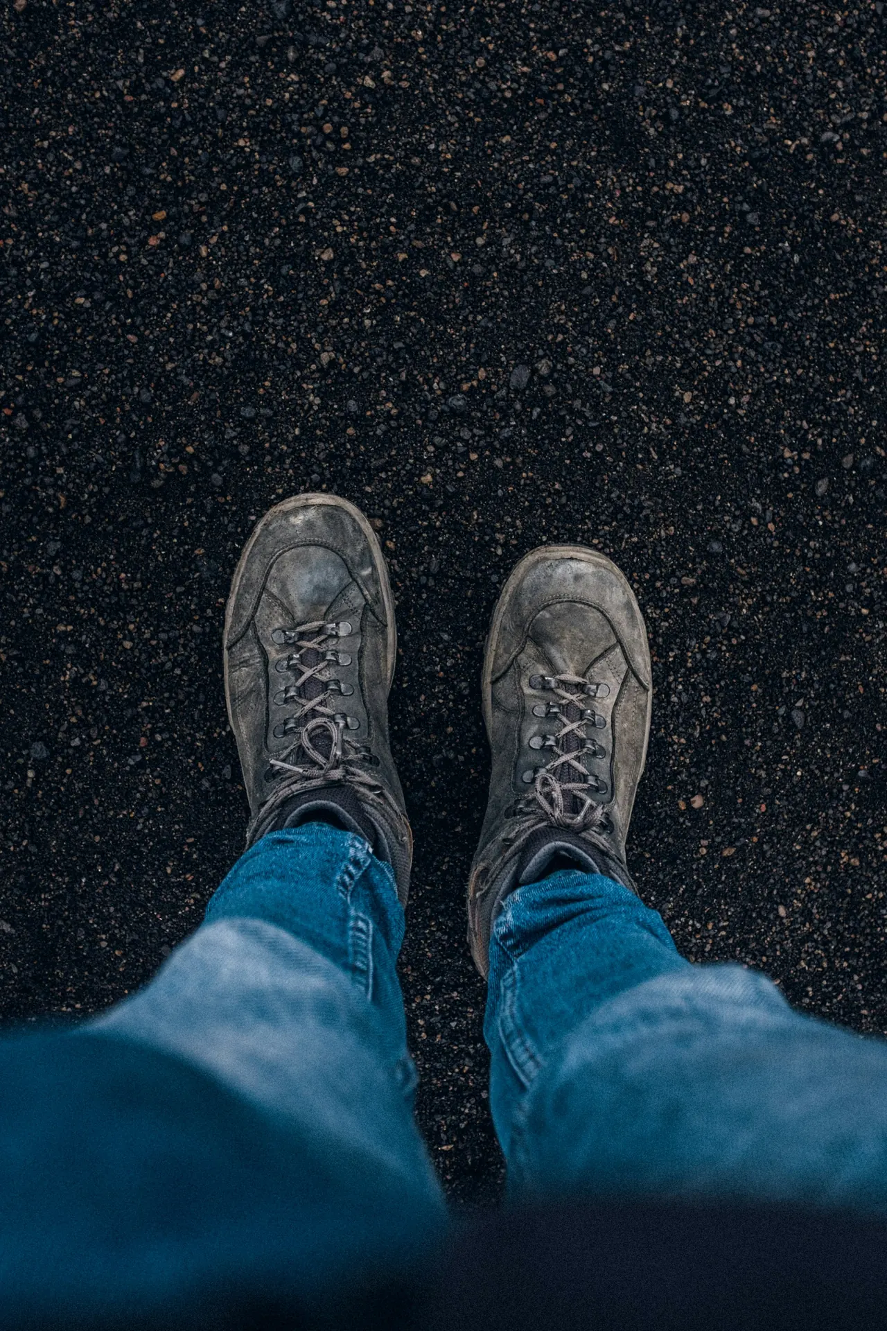 man sitting in dark jeans and suede chelsea boots in a restaurant