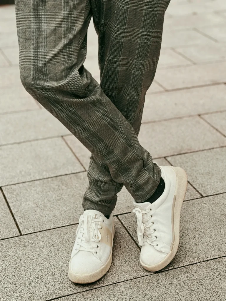 person standing sidewalk wearing white shoes illustrating the best white sneakers under $150