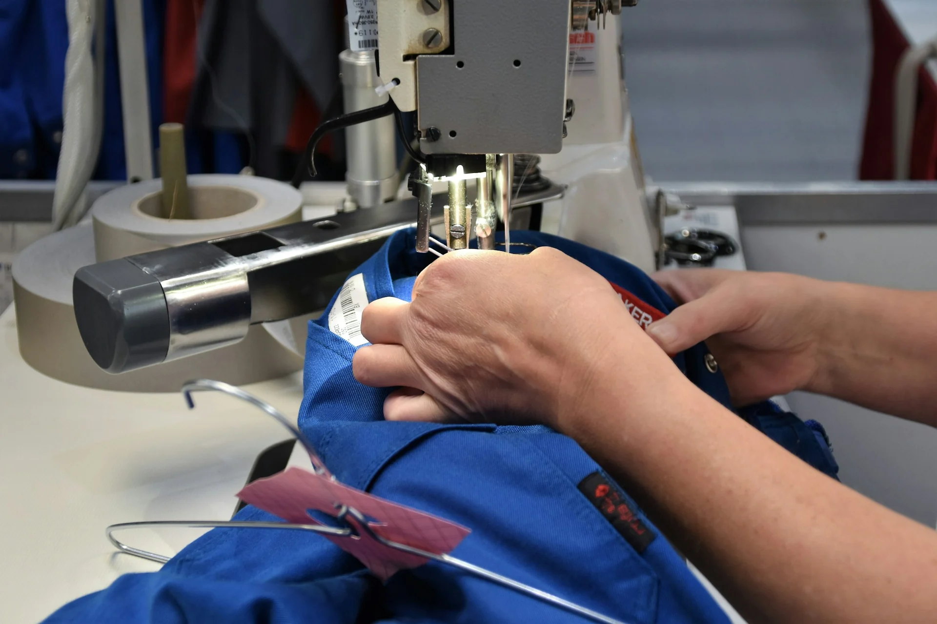tailor measuring the sleeve length of a jacket on a customer