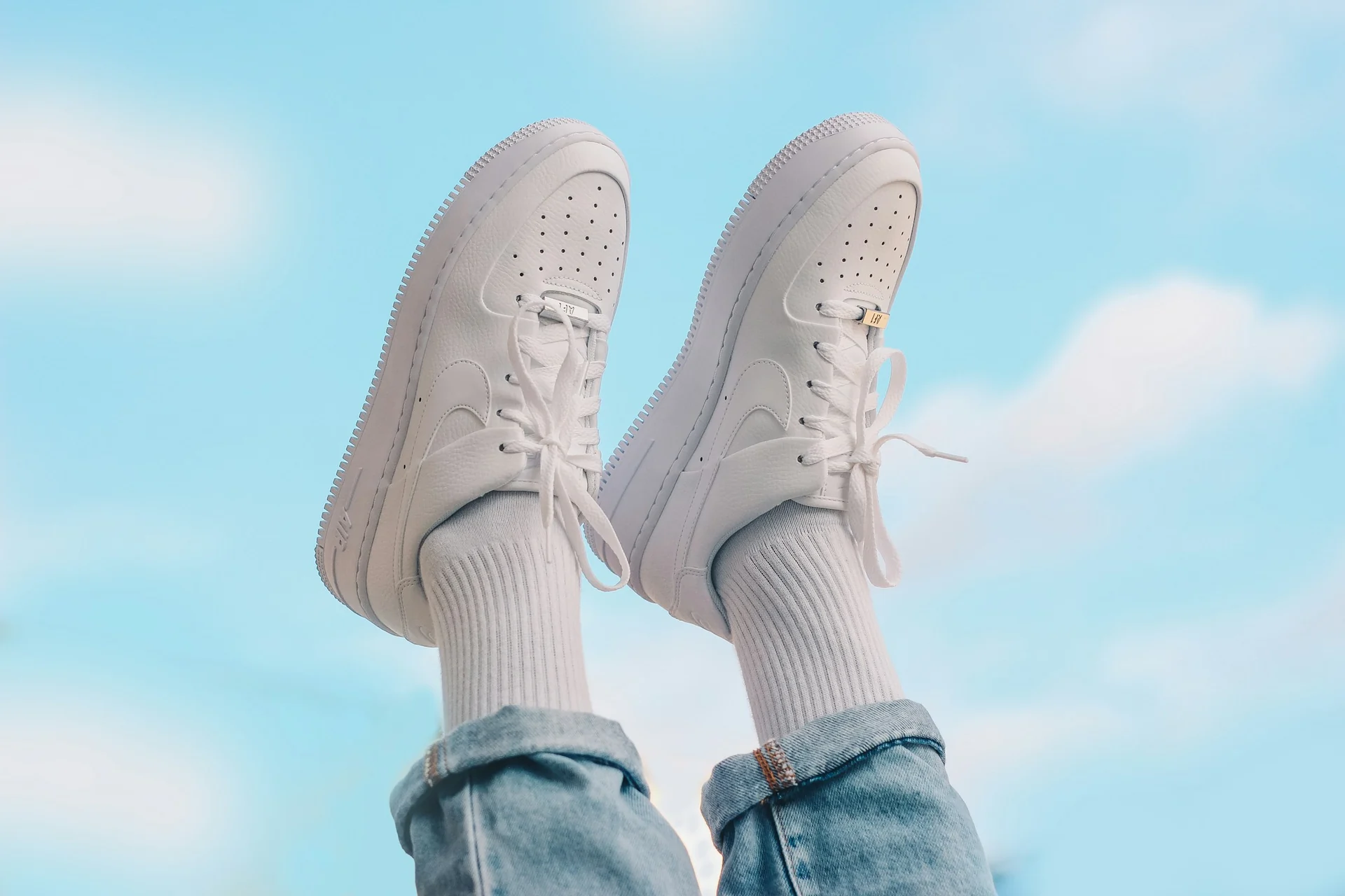 hand wiping a scuff off a white leather sneaker