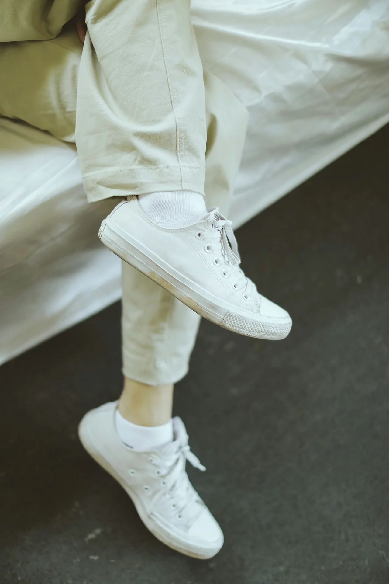 man wearing white leather sneakers with navy chinos