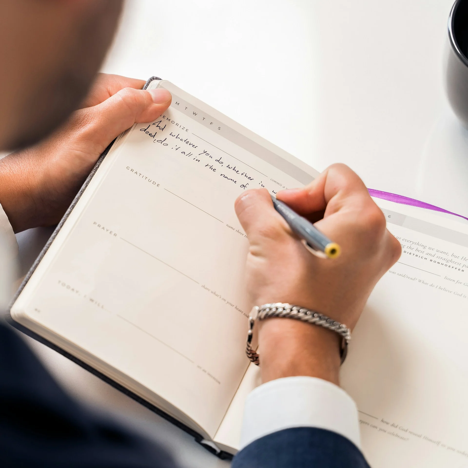 man writing an investment plan in a notebook at a kitchen table
