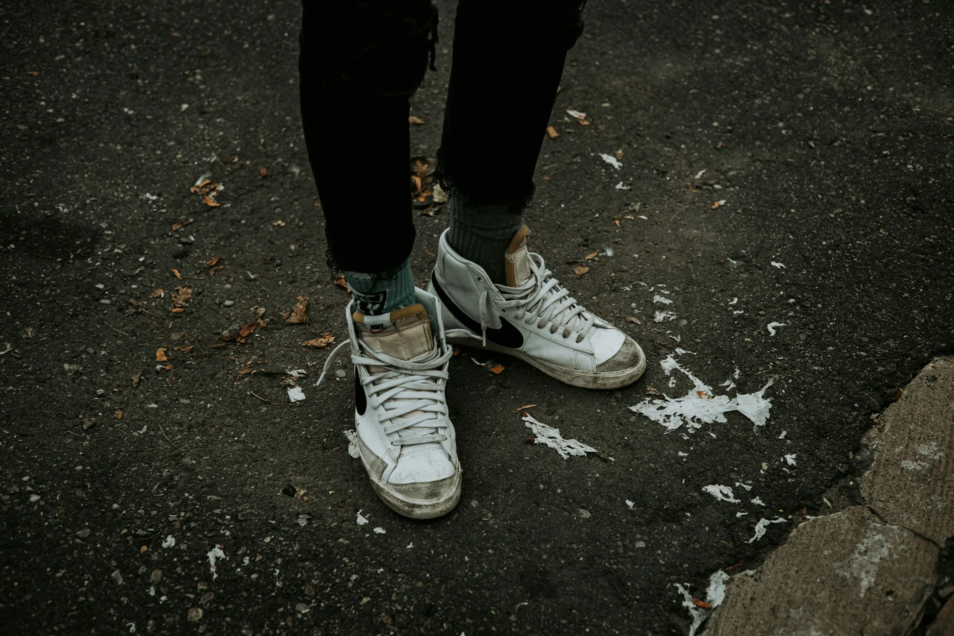 white canvas high-top sneakers standing on a concrete step
