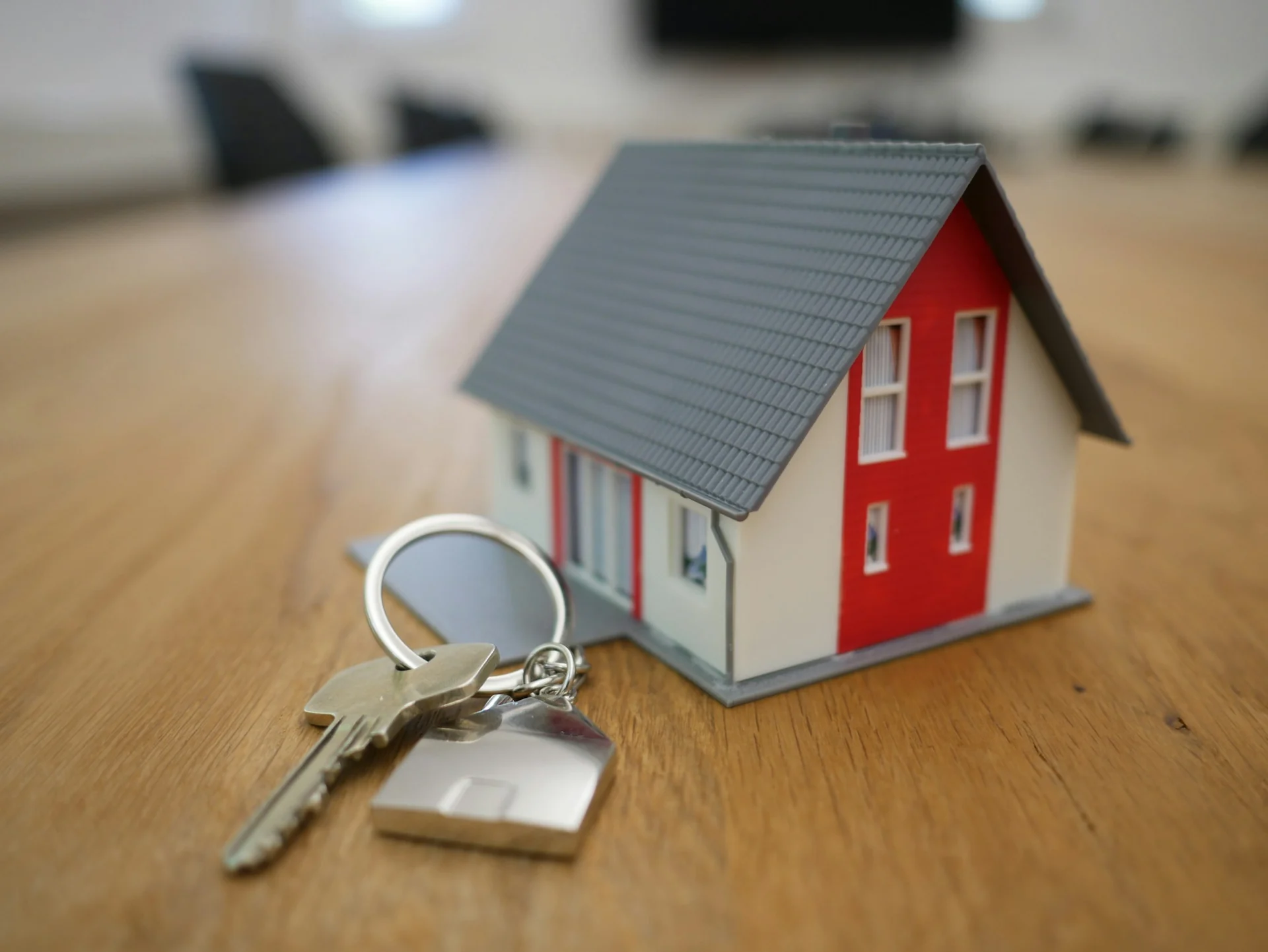 house keys resting beside a lease document on a kitchen table