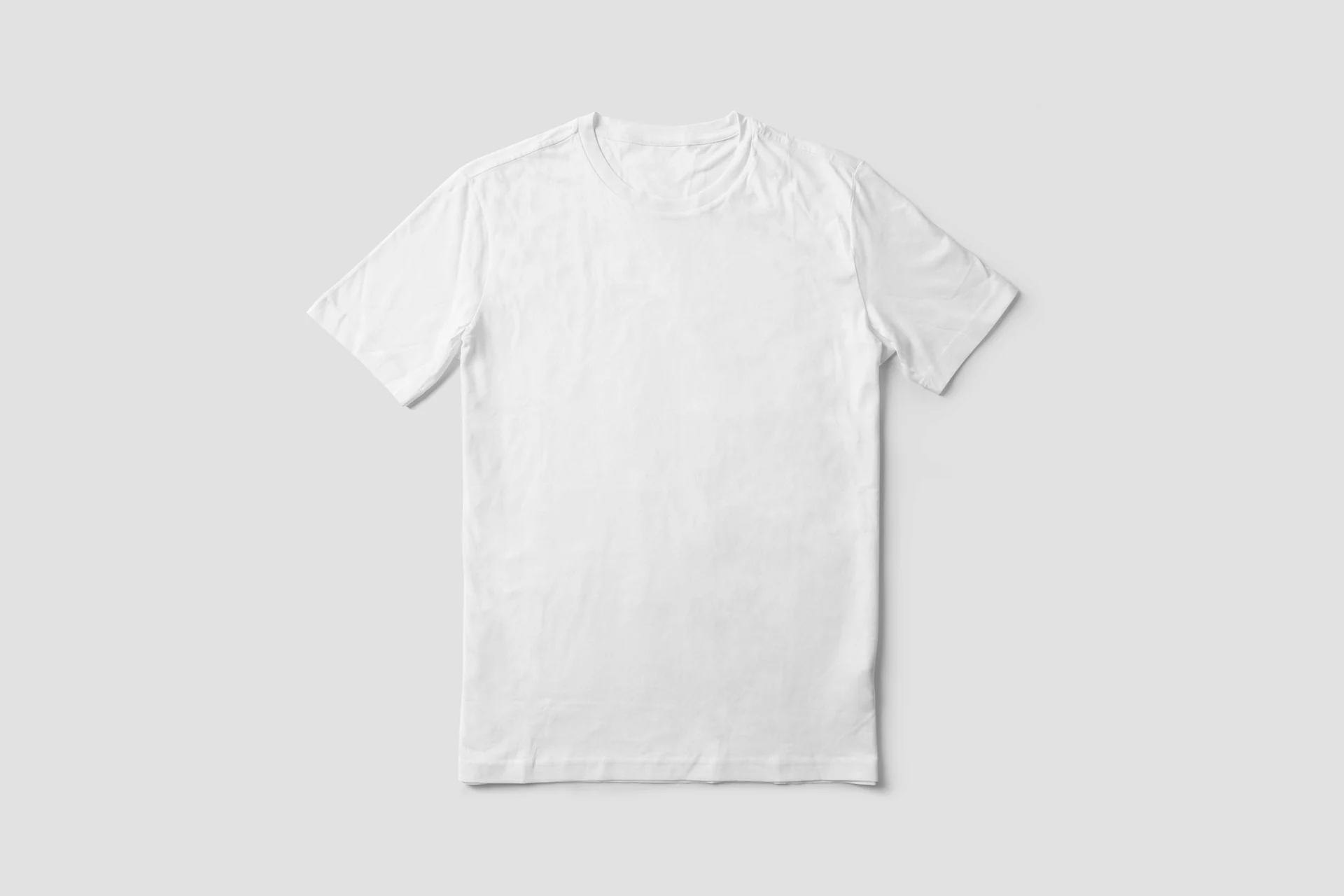 hands folding a heavyweight white t-shirt onto a wardrobe shelf